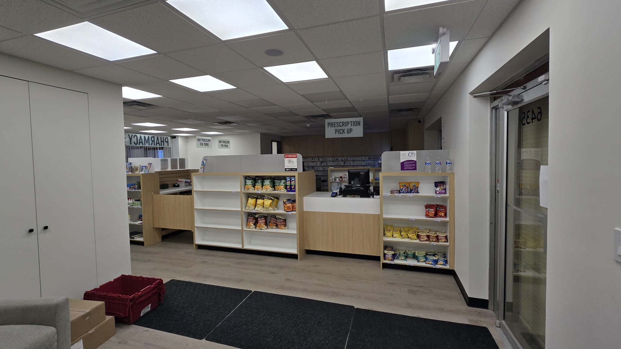 Bow Care Pharmacy counselling room doors beside supplement shelving
