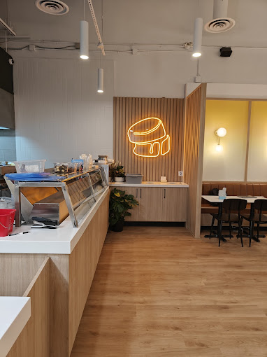 Fuwa Fuwa counter with glowing neon logo beside dining booth