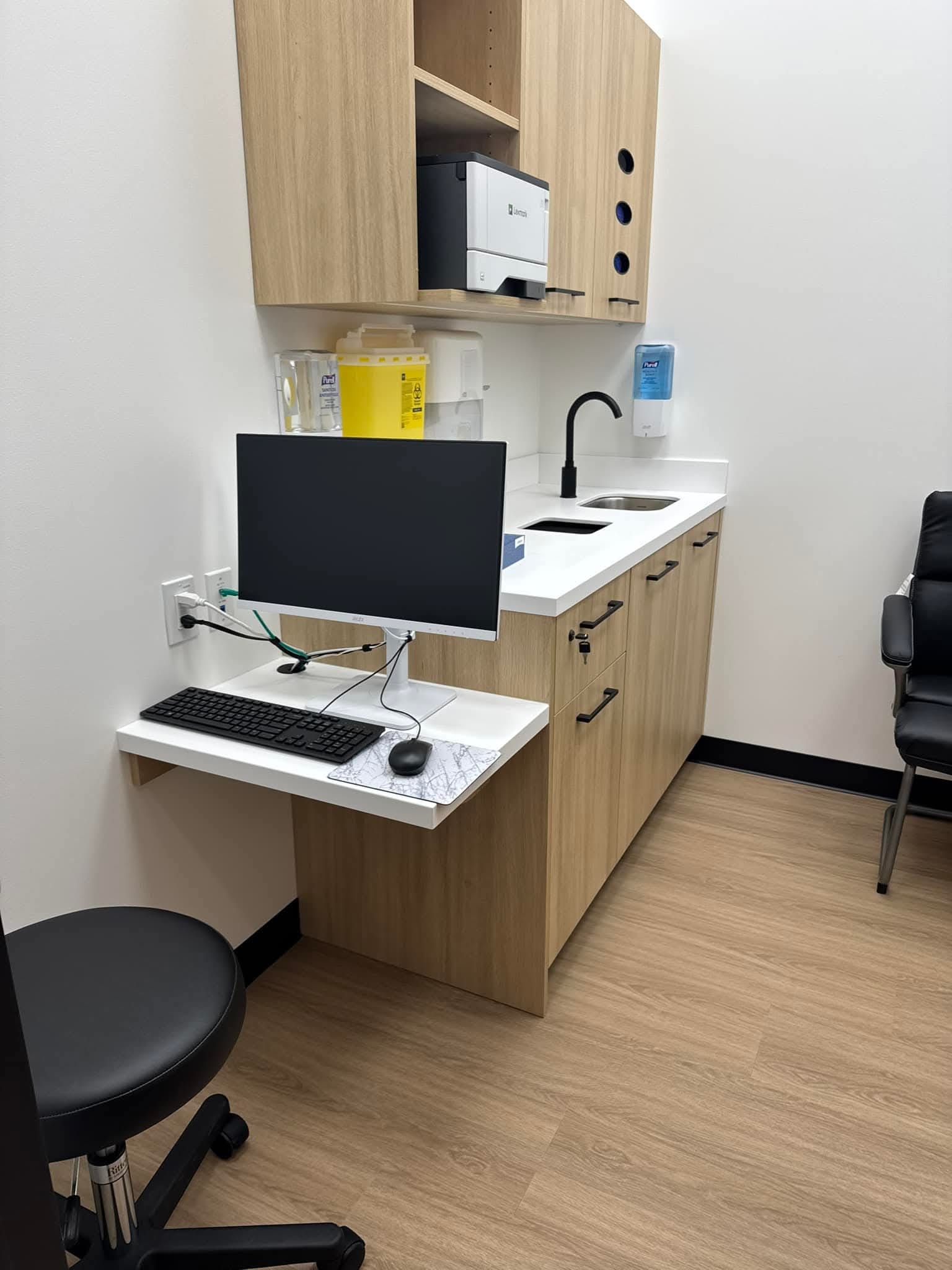 Exam room door signage with wood-grain finish and black accent strip