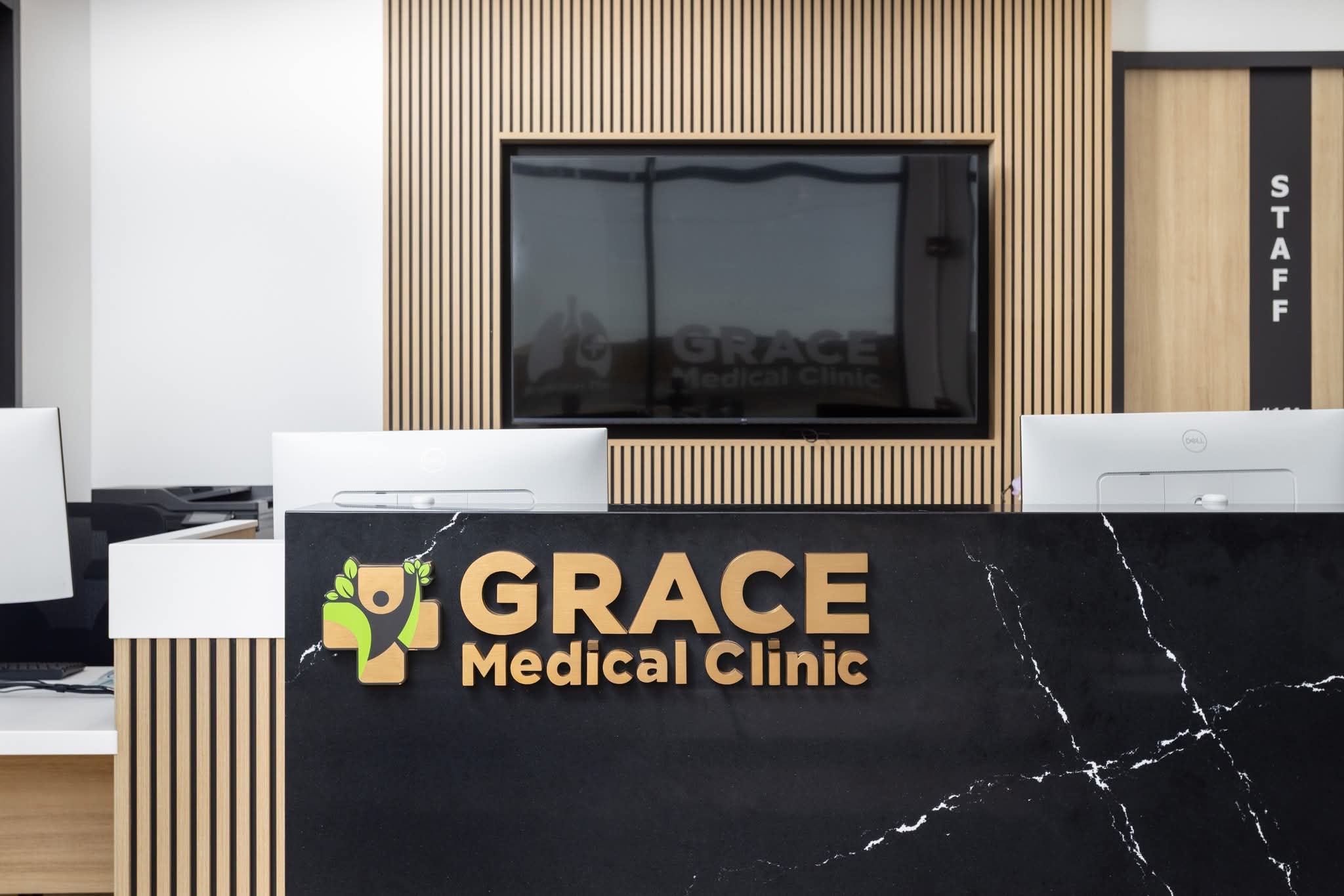 Grace Medical Clinic reception desk with black marble counter and Grace Medical Clinic logo, Sage Hill Calgary