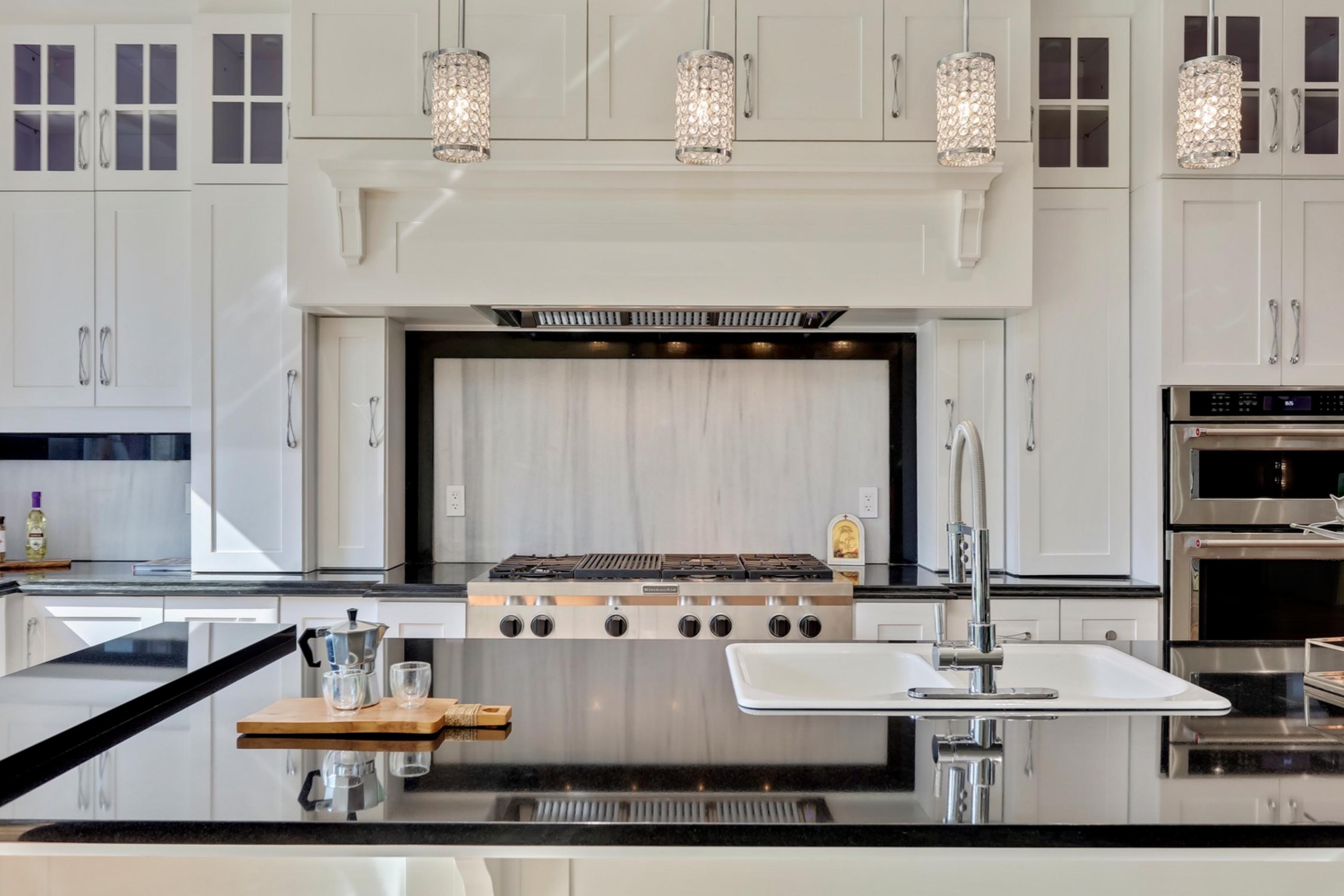 Killarney Custom Residence kitchen with white cabinetry and black countertops