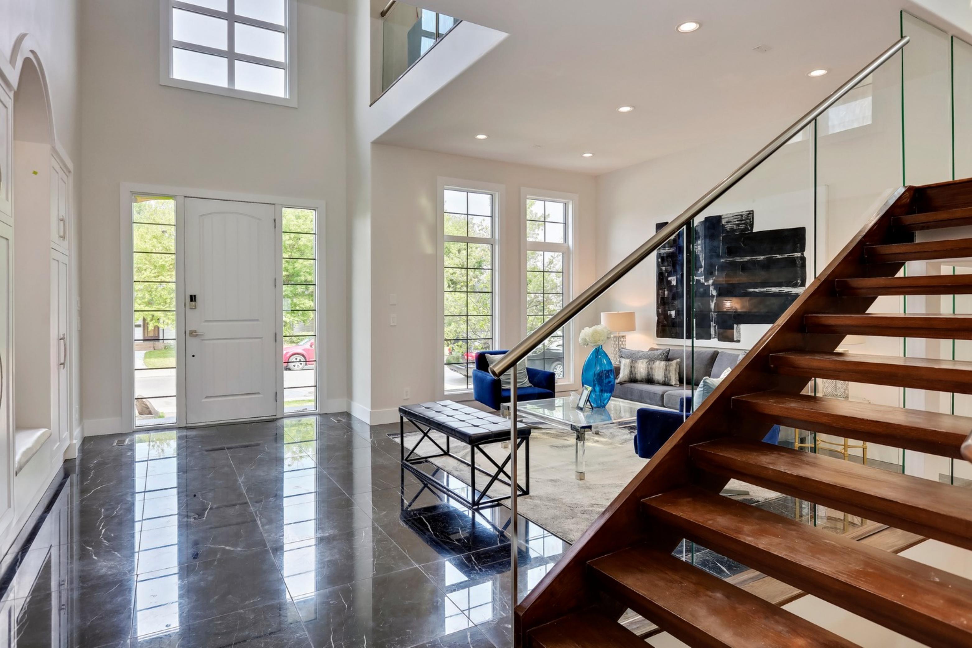 Killarney Custom Residence foyer with marble floor and glass-and-wood open staircase