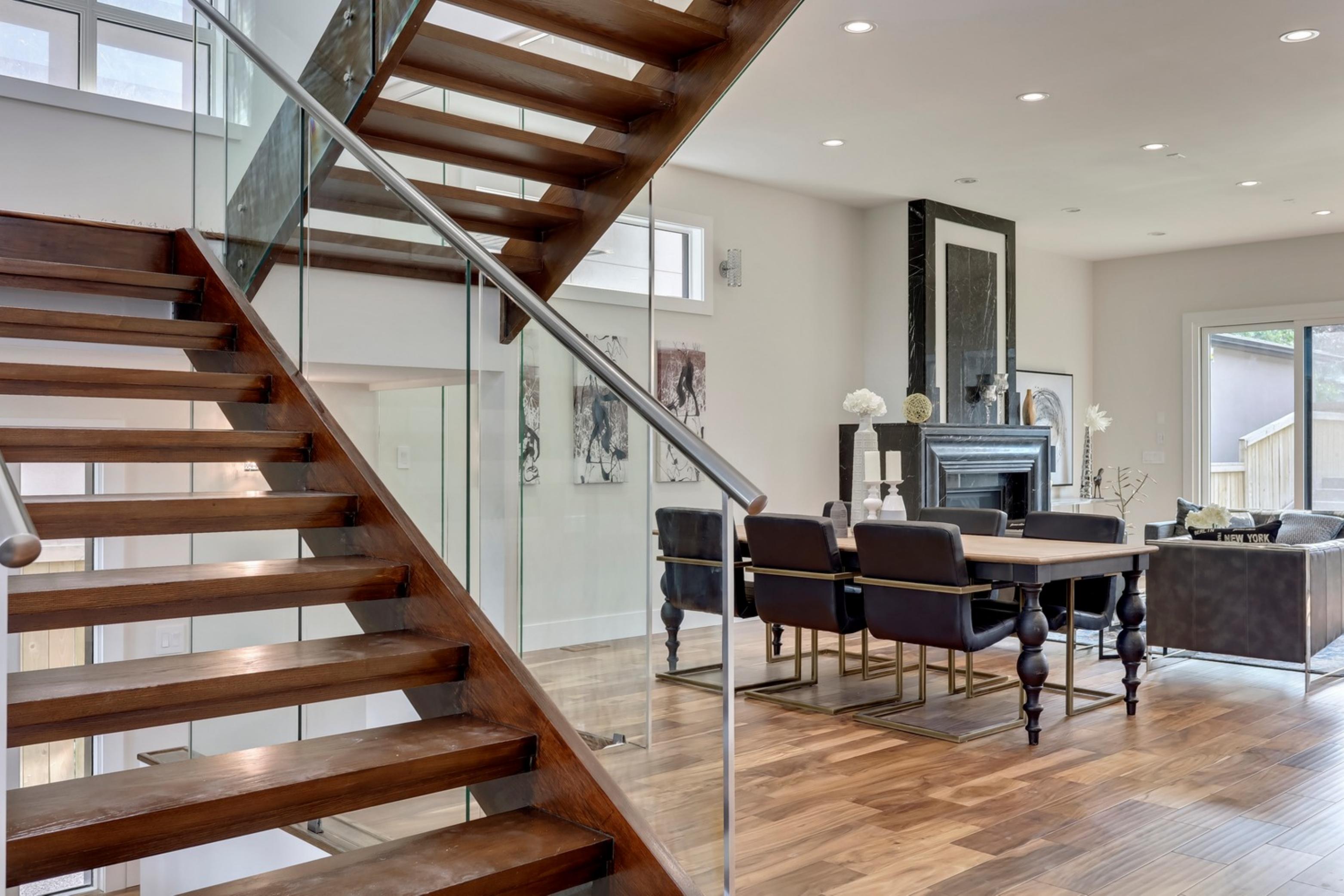 Killarney Custom Residence open-tread staircase with dining area and fireplace beyond