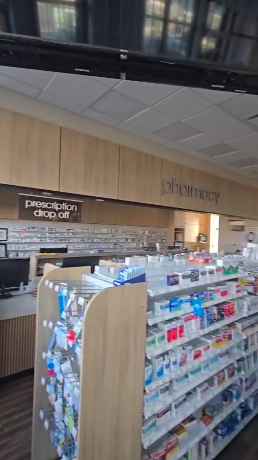 Pharmasave Sage Hill counter with prescription drop-off sign